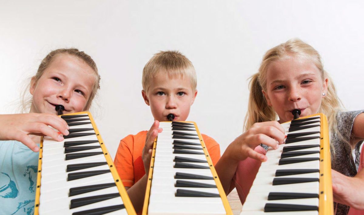 Kinder spielen Melodika